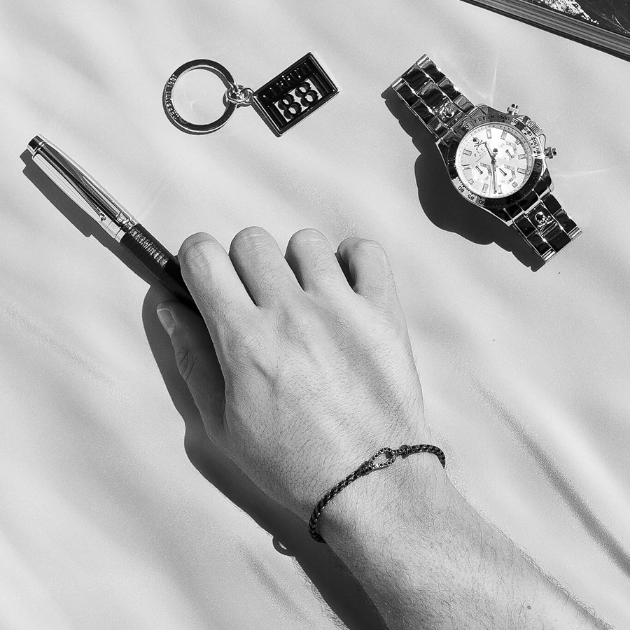 ανδρικό βραχιόλι φορεμένο μαζί με ρολόι, στυλό, μπρελόκ
